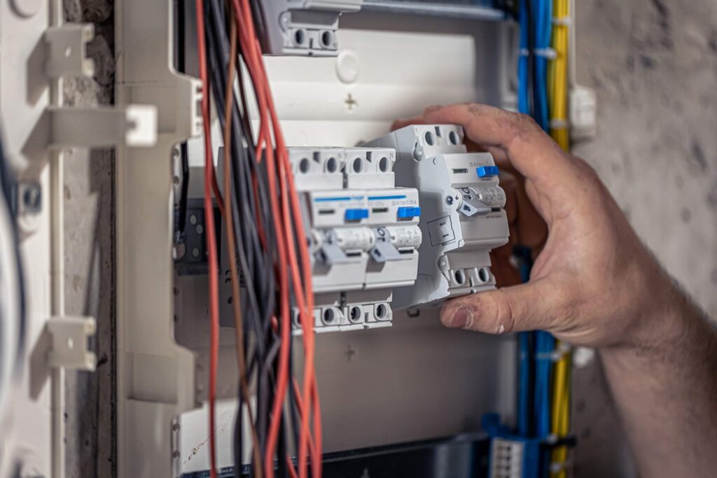 A Male Electrician Works In A Switchboard With An 2023 11 27 05 23 23 7J8VVT4